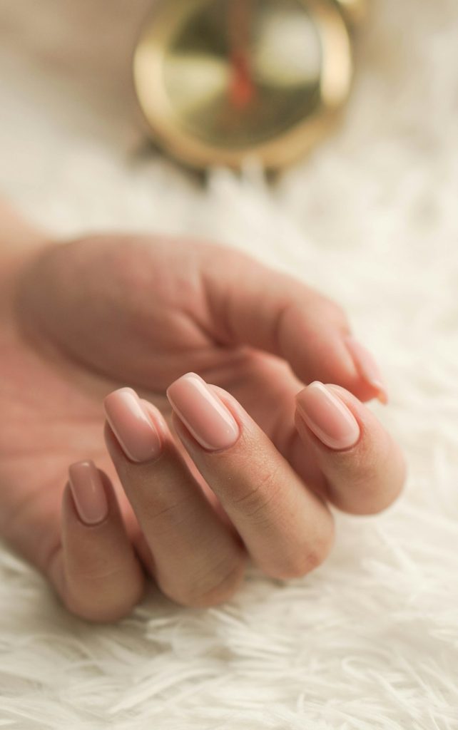 Acasă A woman posing her hands with newly polished nails.